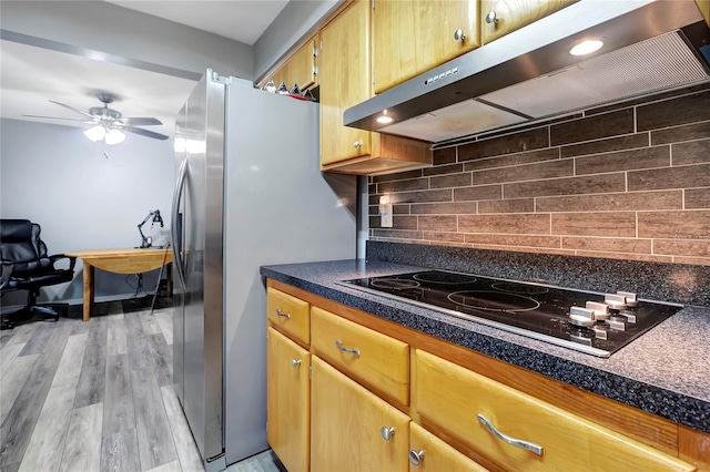 kitchen featuring stainless steel fridge, backsplash, ceiling fan, light hardwood / wood-style flooring, and stovetop