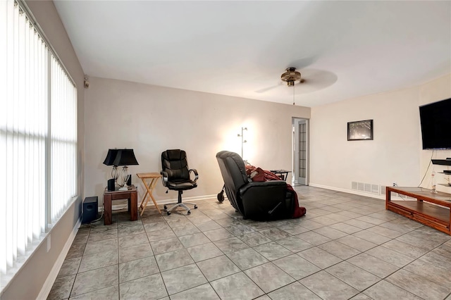 sitting room with light tile patterned floors, plenty of natural light, and ceiling fan