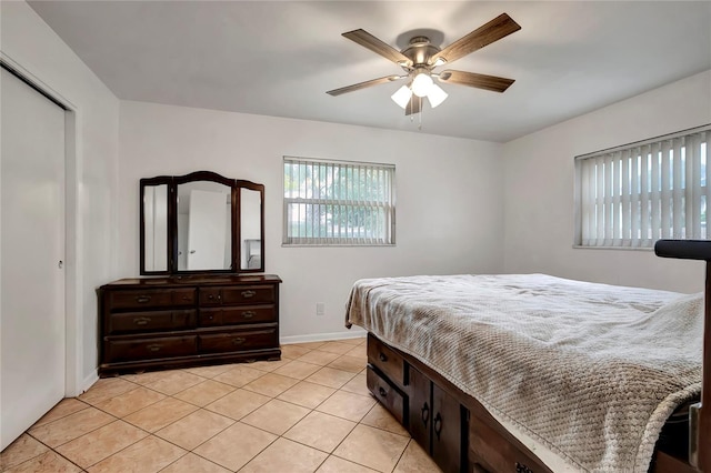 tiled bedroom with ceiling fan and multiple windows