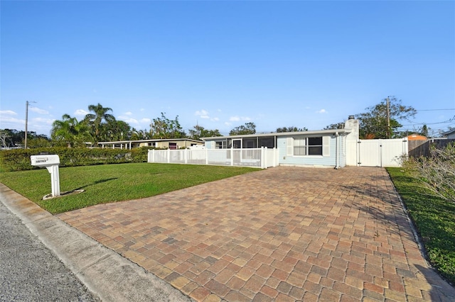 view of front of home with a front yard and a sunroom