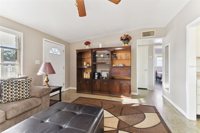 living room with ceiling fan, a healthy amount of sunlight, and vaulted ceiling