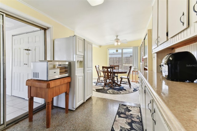 kitchen with ornamental molding, white cabinetry, and ceiling fan