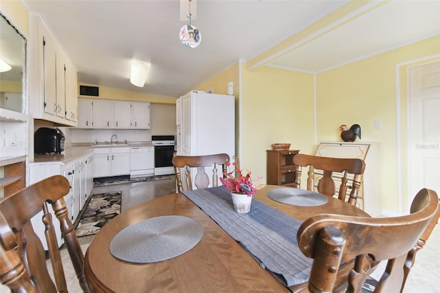 dining space with sink and vaulted ceiling