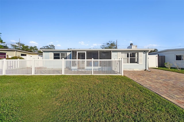 back of property featuring a lawn and a sunroom