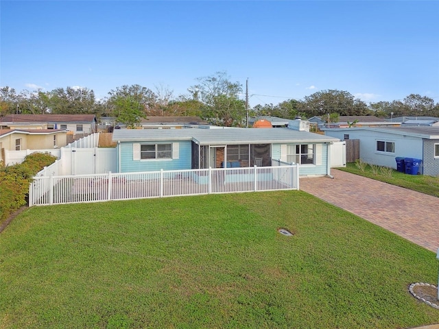 rear view of house with a sunroom and a yard