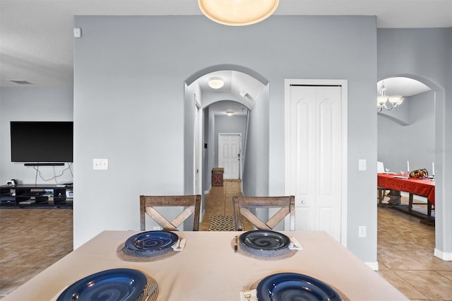 dining room with light tile patterned flooring and an inviting chandelier