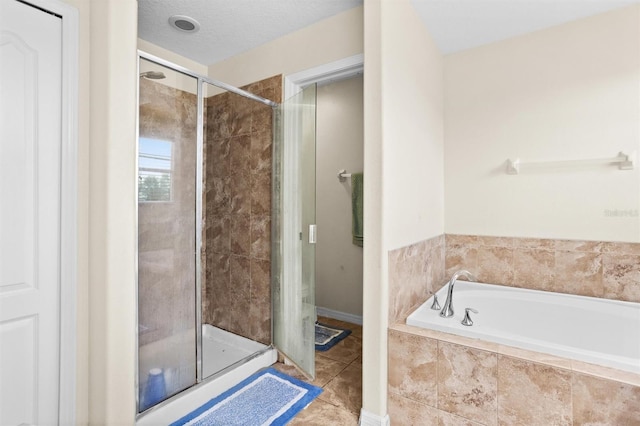 bathroom with a textured ceiling, tile patterned floors, and independent shower and bath