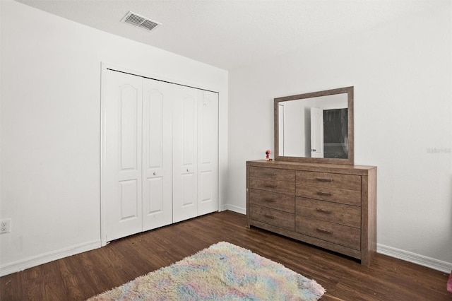 bedroom featuring dark hardwood / wood-style floors and a closet