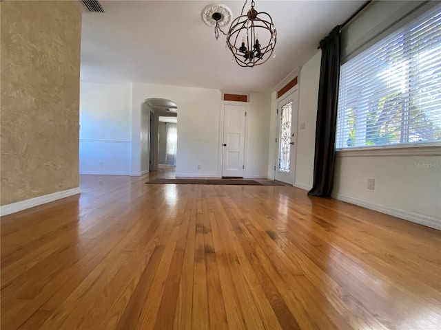 foyer entrance with a notable chandelier and light hardwood / wood-style floors