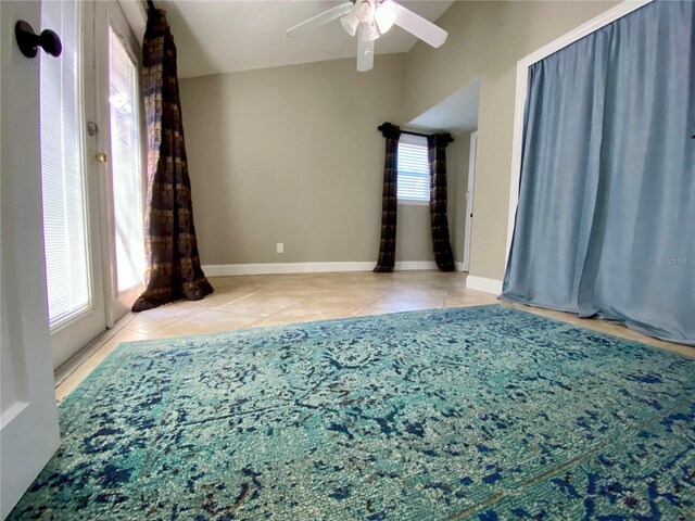 tiled spare room with a wealth of natural light and ceiling fan