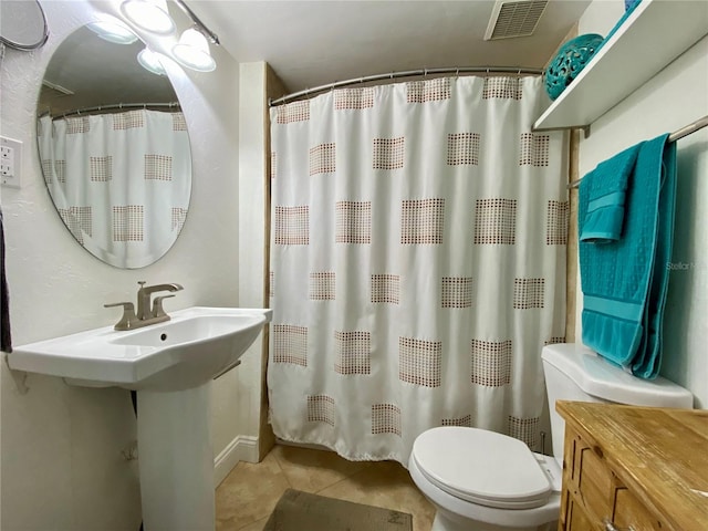 bathroom with tile patterned floors, a shower with curtain, sink, and toilet