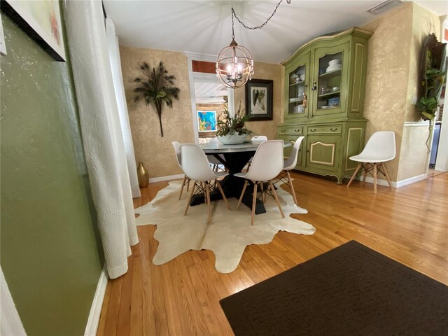 dining space featuring light wood-type flooring and a chandelier