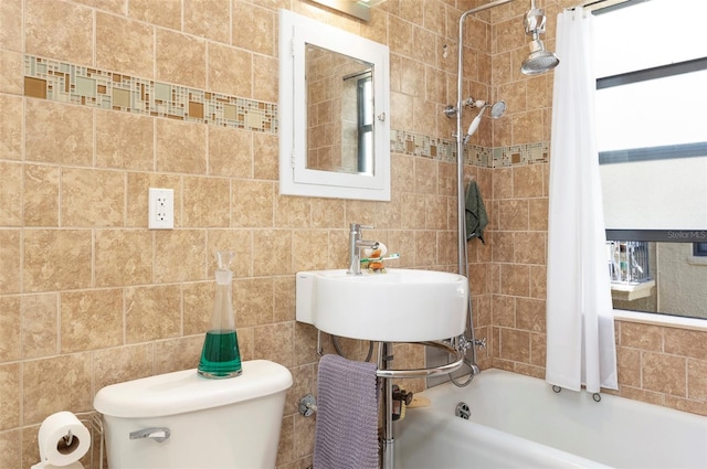 full bathroom with shower / bath combo, toilet, tile walls, and sink