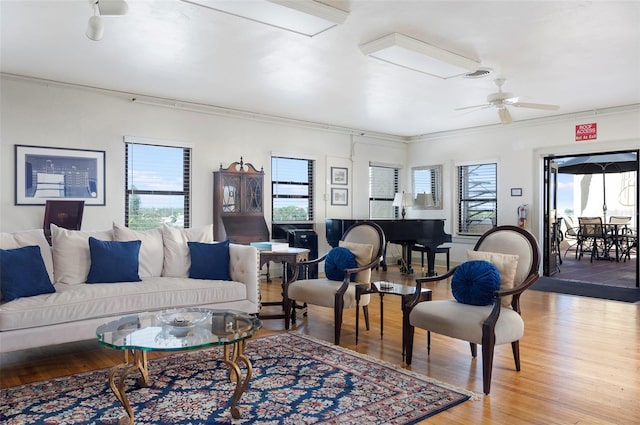 living room with light hardwood / wood-style floors, ceiling fan, and ornamental molding