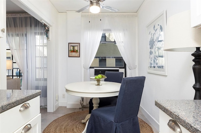 tiled dining room featuring ceiling fan