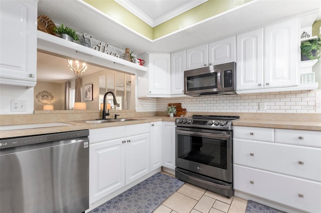 kitchen with crown molding, sink, light tile patterned floors, white cabinetry, and stainless steel appliances