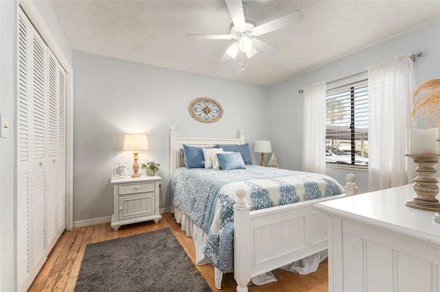 bedroom featuring ceiling fan, light hardwood / wood-style floors, a textured ceiling, and a closet