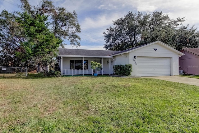 ranch-style home with driveway, a porch, a front lawn, and an attached garage