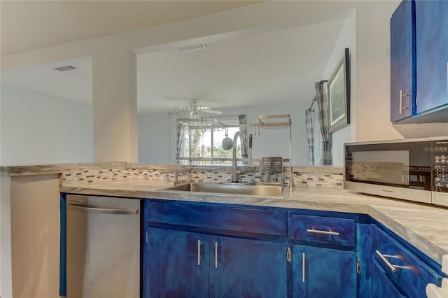 kitchen featuring appliances with stainless steel finishes, tasteful backsplash, blue cabinets, and sink