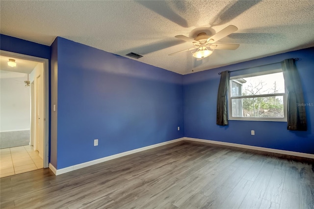 unfurnished room featuring hardwood / wood-style floors, ceiling fan, and a textured ceiling