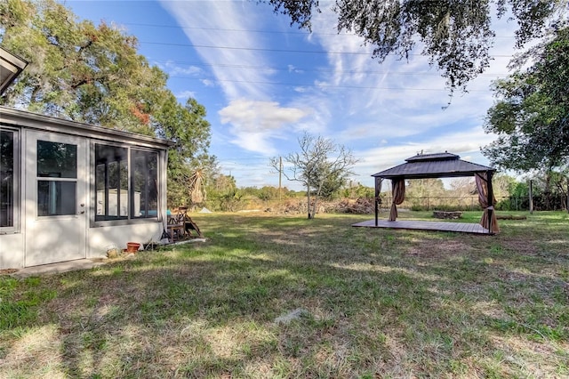 view of yard featuring a gazebo and a sunroom