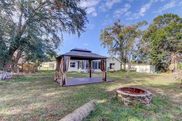 view of yard with a gazebo, a storage shed, an outdoor fire pit, and a wooden deck