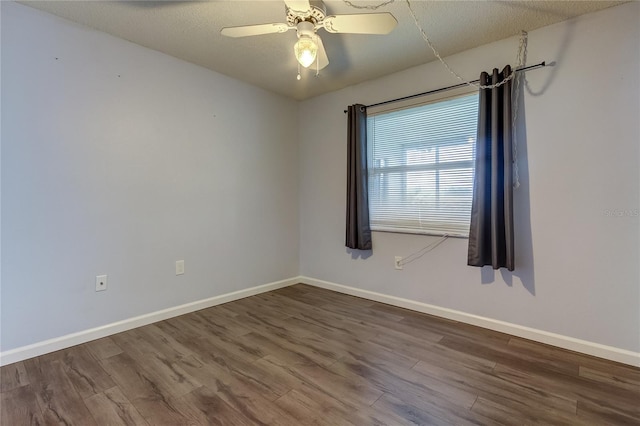 unfurnished room featuring a textured ceiling, baseboards, and wood finished floors