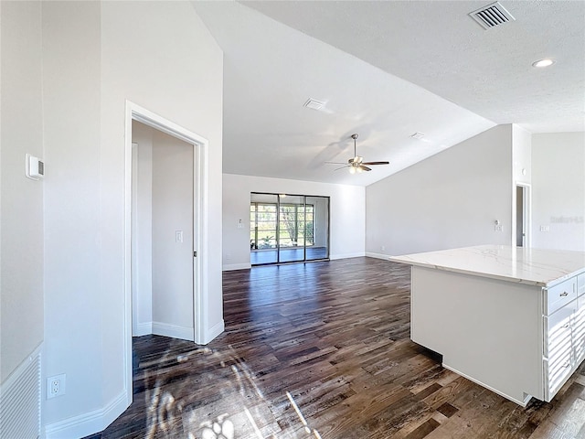 unfurnished living room with a textured ceiling, ceiling fan, dark wood-type flooring, and lofted ceiling