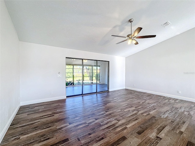 empty room with a textured ceiling, dark hardwood / wood-style flooring, vaulted ceiling, and ceiling fan