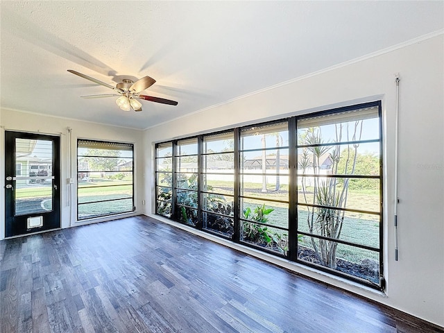 unfurnished room with a textured ceiling, dark hardwood / wood-style flooring, ceiling fan, and ornamental molding