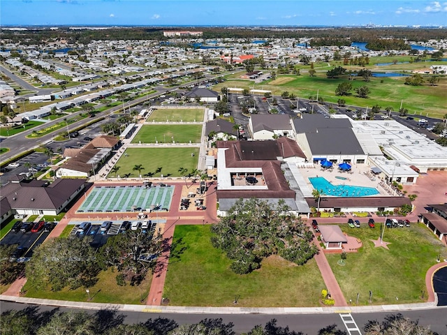 aerial perspective of suburban area featuring a nearby body of water and a pool