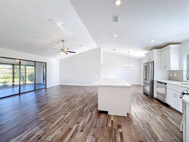 kitchen with appliances with stainless steel finishes, dark wood-style flooring, a chandelier, a ceiling fan, and baseboards