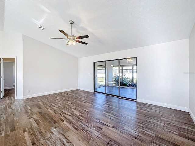 spare room featuring vaulted ceiling, a ceiling fan, wood finished floors, and baseboards
