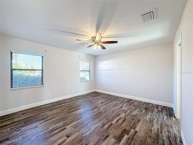 unfurnished room with dark wood-style floors, a textured ceiling, a ceiling fan, and baseboards