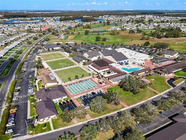 aerial view of property and surrounding area with a large body of water and a pool