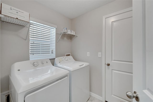 laundry area featuring washer and clothes dryer and a textured ceiling