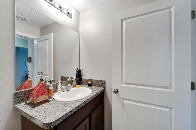 bathroom featuring a textured ceiling and vanity