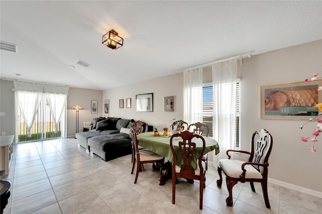 dining room with a healthy amount of sunlight and light tile patterned flooring