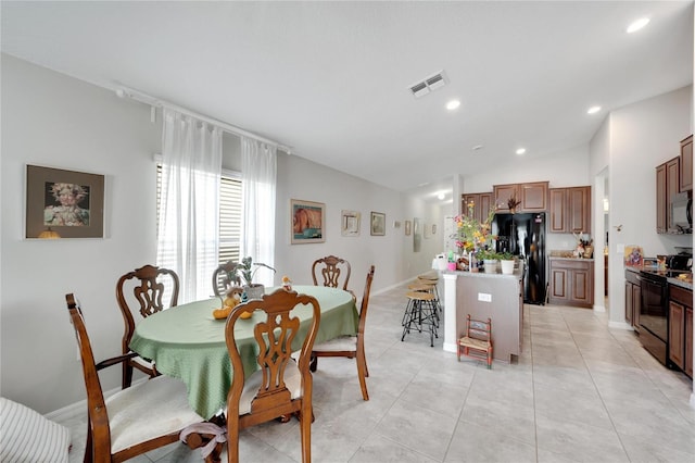 dining area with light tile patterned floors and vaulted ceiling