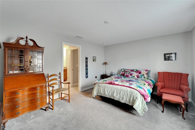 bedroom featuring light colored carpet and a textured ceiling