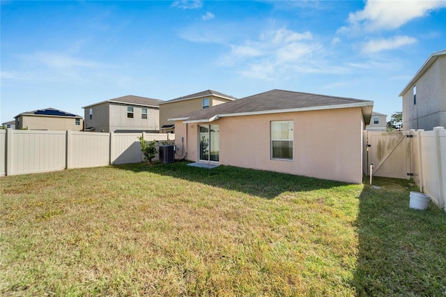 rear view of property with a yard and cooling unit