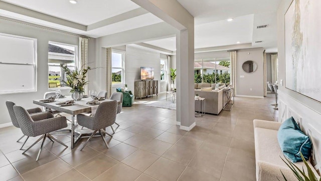 tiled dining space featuring a tray ceiling