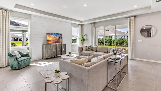 tiled living room featuring a tray ceiling