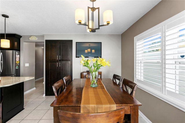 dining space with a notable chandelier, light tile patterned floors, and a textured ceiling