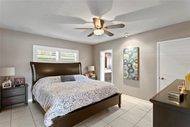 bedroom featuring connected bathroom, ceiling fan, light tile patterned floors, and a textured ceiling