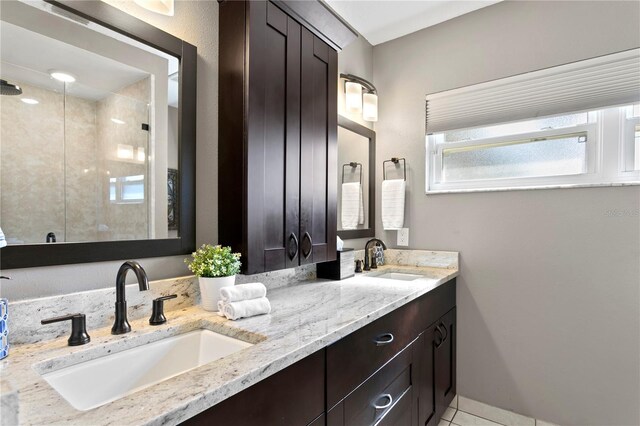 bathroom featuring tile patterned flooring, vanity, and walk in shower