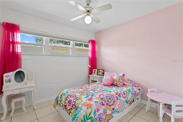 bedroom featuring ceiling fan, light tile patterned floors, and brick wall