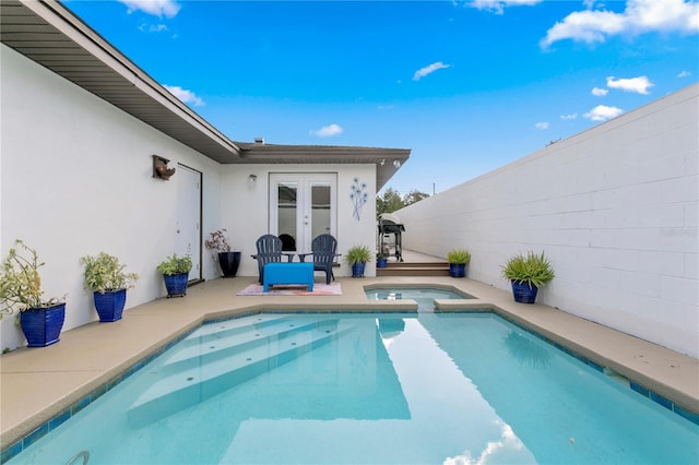 view of pool with an in ground hot tub, french doors, a patio, and area for grilling