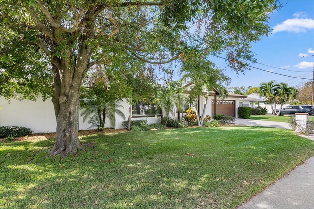 3401 W N B St, Tampa, FL 33609 - view of front of property featuring an attached garage, concrete driveway, a front lawn, and stucco siding