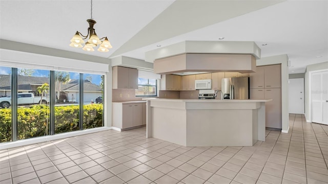 kitchen featuring tasteful backsplash, stainless steel appliances, vaulted ceiling, light tile patterned floors, and an island with sink